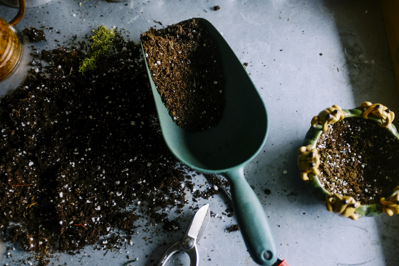 Potting soil and gardening tools on a nursery workbench